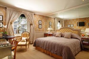 a bedroom with a bed and a desk and a chair at Summer Lodge Country House Hotel in Evershot