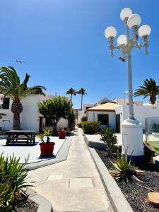a walkway with palm trees and a street light at El sueño de mi vida in Caleta De Fuste