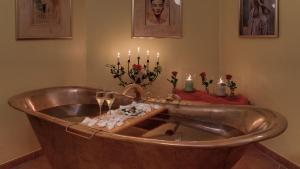 eine Kupferbadewanne mit Kerzen und einen Tisch mit Rosen in der Unterkunft Der Romantik-Hof Greetsiel in Greetsiel