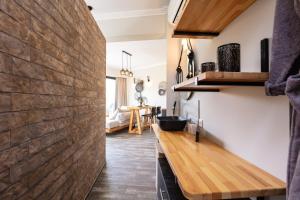 a kitchen with a wooden counter and a brick wall at Tripiti Cozy Flat in Damnoni