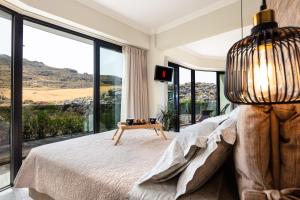 a bedroom with a bed and a large glass window at Tripiti Cozy Flat in Damnoni