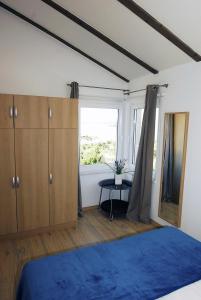 una camera con un letto blu e una finestra di Apartments Maslina a Primošten