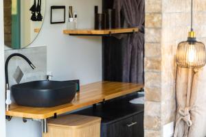 a bathroom with a black bowl sink on a wooden counter at Tripiti Cozy Flat in Damnoni