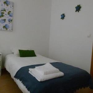 um quarto com uma cama com toalhas em Watching Azores Apartment em Ponta Delgada