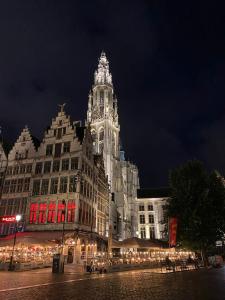 a large building with a clock tower at night at Grote Markt suite 3 in Antwerp