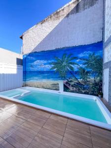 a swimming pool with a mural on a wall at Dúplex Paracuru in Paracuru