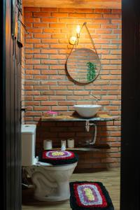a bathroom with a toilet and a brick wall at Nostra Habitazione in Ascurra