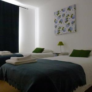 um quarto com 2 camas e uma janela em Watching Azores Apartment em Ponta Delgada