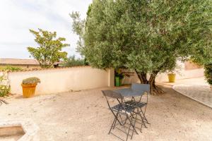 una mesa y sillas sentadas junto a un árbol en Gite En Provence, en Saze