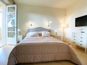 a bedroom with a bed and a tv on the wall at Villa Ginevra - Luxury Villa in Forte dei Marmi +12 photos
