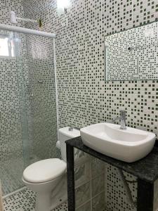 a bathroom with a sink and a toilet and a shower at Residencial Refugio do Mar in Florianópolis
