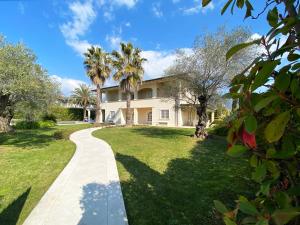 a house with palm trees and a walkway at Villa Ginevra - Luxury Villa in Forte dei Marmi