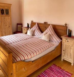 PatersdorfにあるFerienhaus Kitzkeの大きな木製ベッド(枕付)が備わるベッドルームです。