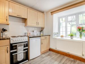 eine Küche mit weißen Geräten und einem Fenster in der Unterkunft 2 Bed in Bridport 93342 in Powerstock + 15 Fotos