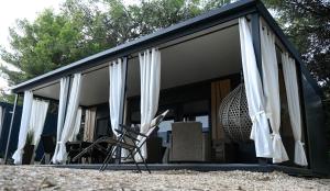 a room with white curtains and a chair at Mobile home Periska, Pakoštane in Pakoštane