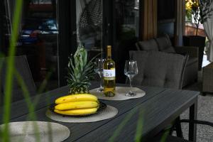 a table with a bunch of bananas and a bottle of wine at Mobile home Periska, Pakoštane in Pakoštane