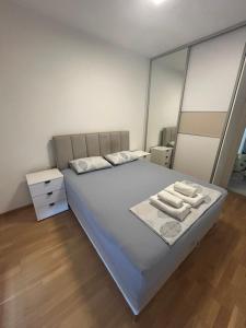 a bedroom with a bed with two towels on it at Apartmani Odmor in Podgorica