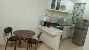 a small kitchen with a table and a refrigerator at Richie Homes in Kampala