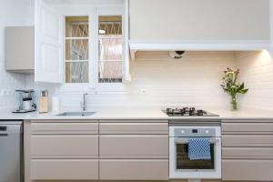 a kitchen with white cabinets and a stove top oven at Lovely Designed House Connected To Center in Cornellà de Llobregat
