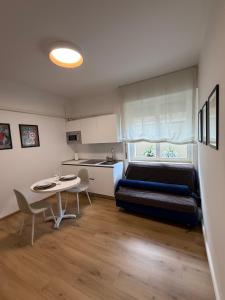 a room with a bed and a table and a kitchen at GORGHI House in Udine