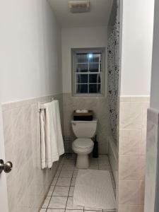 bagno con servizi igienici, finestra e asciugamani di Exclusive 2 beds 2 bath near EWR downtown Newark a Newark Altre 13 foto