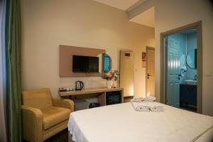 a room with a bed and a chair and a television at Casa Maria Hotel in Antalya