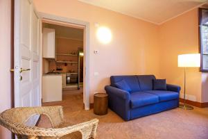 a living room with a blue chair and a kitchen at Villa Scagliola in Verbania