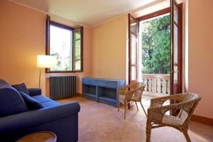 a living room with a blue couch and chairs at Villa Scagliola in Verbania