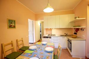a kitchen with a table and chairs and a kitchen with white cabinets at Villa Scagliola in Verbania