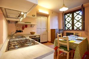 cocina con fogones y mesa de comedor. en Villa Scagliola, en Verbania