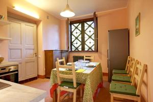 a kitchen with a table with chairs and a refrigerator at Villa Scagliola in Verbania +11 photos