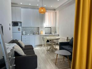 Una sala de estar y una cocina con un sofá y una mesa. en STUDIO near the Round garden, en Tiflis