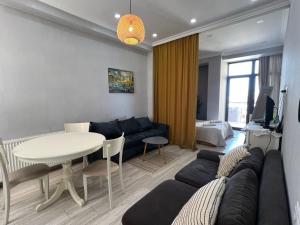 una sala de estar con un sofá y una mesa en STUDIO near the Round garden, en Tiflis