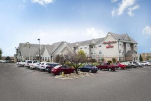 Un gran edificio con coches aparcados en un estacionamiento. en Residence Inn Colorado Springs South, en Colorado Springs