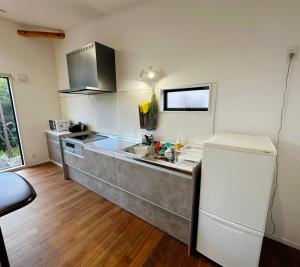 a kitchen with a sink and a refrigerator at Kaede 楓 in Kusatsu
