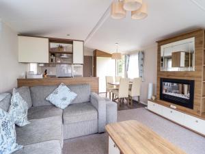 a living room with a couch and a table at Sea Breeze C38 Dyffryn Seaside Estate in Dyffryn