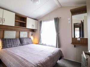 a bedroom with a large bed and a window at Sea Breeze C38 Dyffryn Seaside Estate in Dyffryn