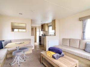 a living room with a couch and a table at Beachcombers Barmouth Bay Holiday Park in Talybont