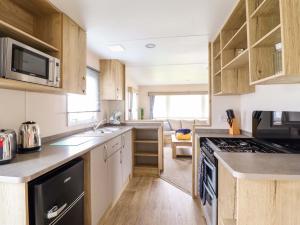 a kitchen with a sink and a stove top oven at Beachcombers Barmouth Bay Holiday Park in Talybont +9 photos