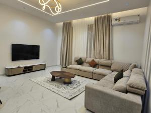 a living room with a couch and a flat screen tv at Ubar-Salalah in Salalah