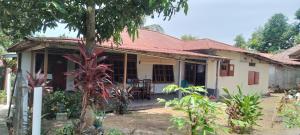 a small white house with a red roof at Bunaken Jhon Homestay in Manado