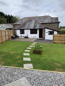 a garden with a house and a pathway at Horseshoe Cottage in Looe