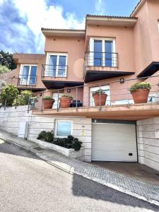 ein großes rosa Gebäude mit Blumentöpfen darauf in der Unterkunft Impresionantes Vistas Mar en el centro de Begur in Begur