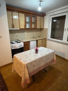 a kitchen with a table with a vase of flowers on it at Drenis Home in Prizren