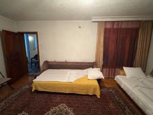a bedroom with two beds and a window at Drenis Home in Prizren