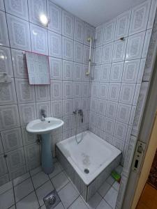 a bathroom with a bath tub and a sink at Drenis Home in Prizren