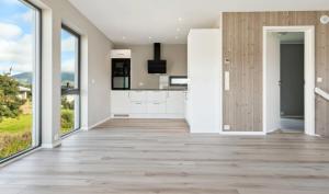 cocina con armarios blancos y ventanas grandes en Central No6, en Vestvågøya