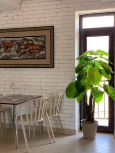 a dining room with a table and a potted plant at RAZAM Hotel Bosteri in Bosteri
