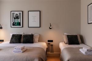 two beds in a room with two towels at Hotel Rose Red in Bruges