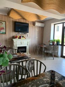 a living room with tables and chairs and a fireplace at RAZAM Hotel Bosteri in Bosteri +23 photos